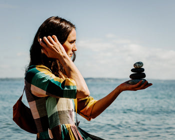 Woman Balancing stones in her hand on the beach