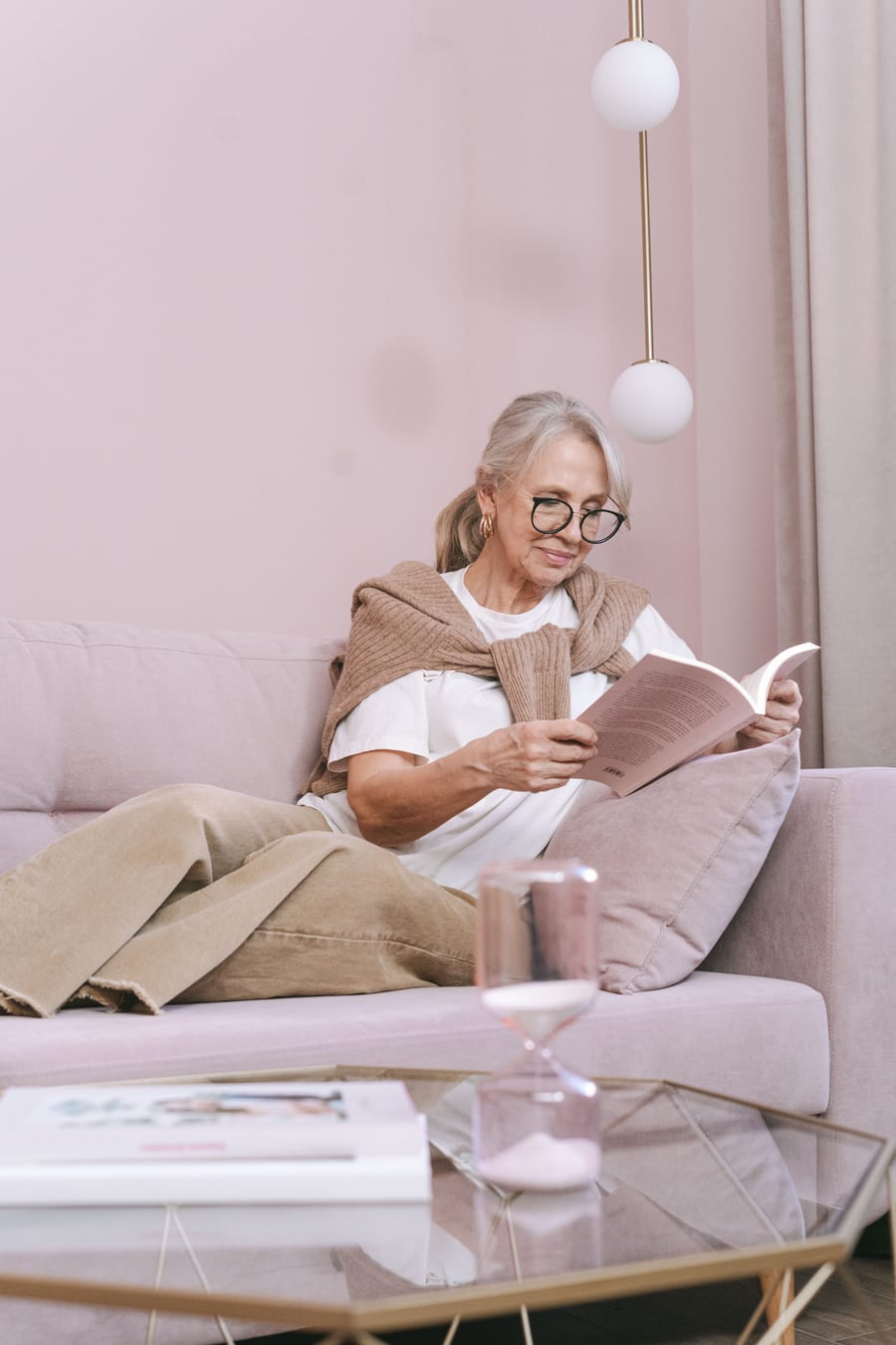 A woman reading quietly on a sofa in soft light